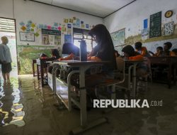 Potret Siswa SDN Eretan Serang Belajar di Ruang Kelas yang Terendam Banjir